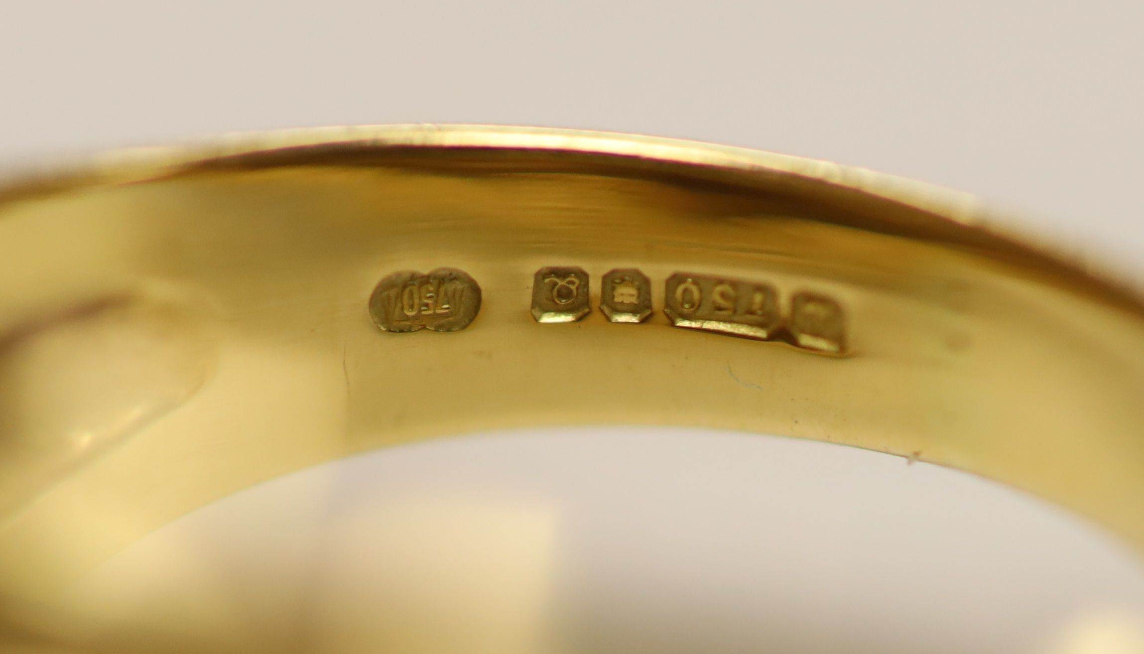 An early 1990's Cartier 18ct gold, black onyx and emerald set twin leopard's head crossover ring